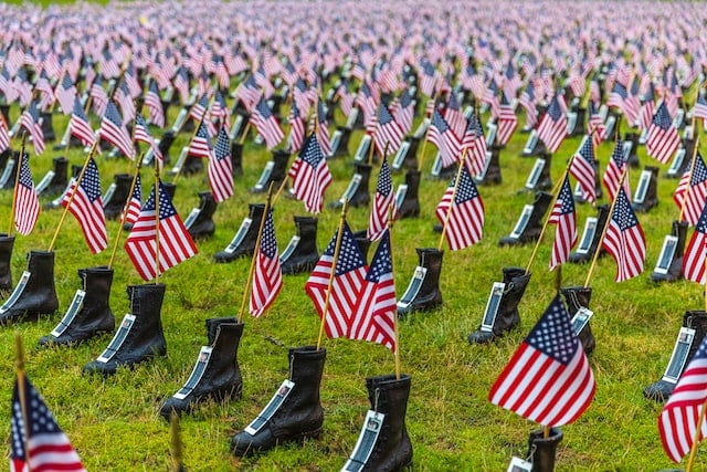 American flag being placed at a gravesite, symbolizing honor and military remembrance, often coordinated by funeral homes in Rohnert Park, CA for veteran funeral services and memorial tributes.