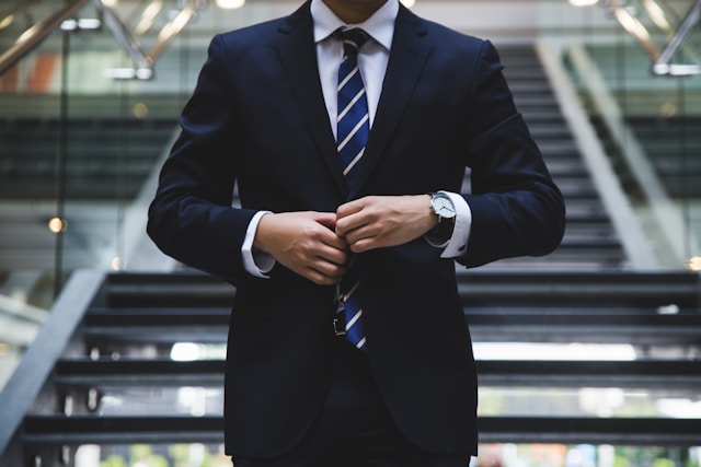 Professional funeral director adjusting suit, representing dignity and care, commonly seen at funeral homes in Healdsburg, CA providing compassionate guidance during memorial services and arrangements.